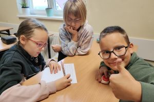 Trójka dzieci z kciukami podniesionymi w górę