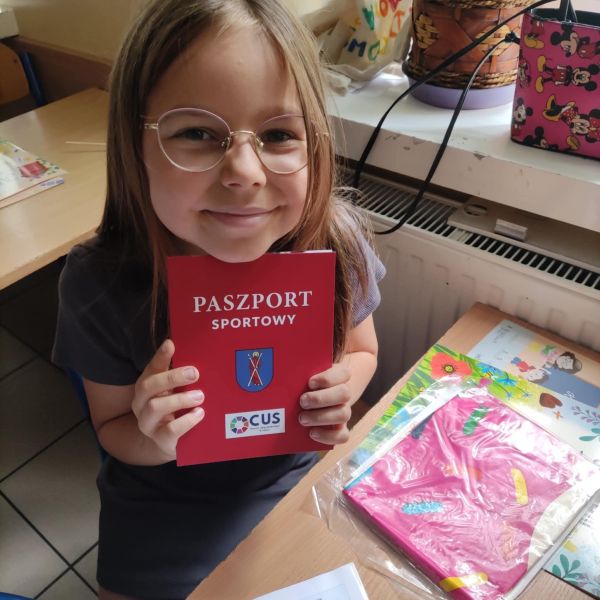 Dziewczynka z Paszportem Sportowym w ręku