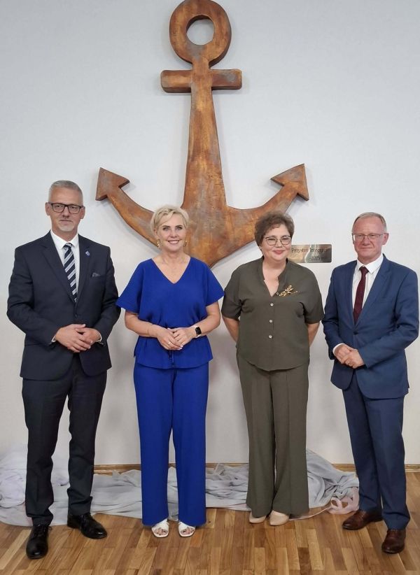 cztery osoby, w tle na ścianie duża kotwica