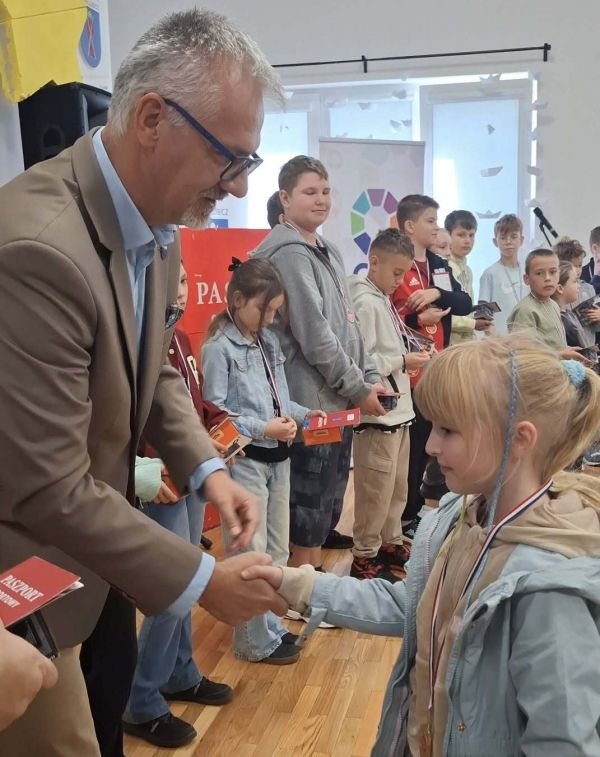 Wójt Marek Nicewicz wręcza medal dziewczynce