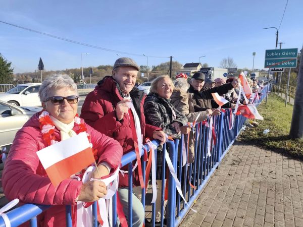 Seniorzy na moście z flagami Polski