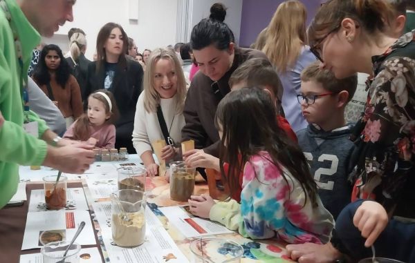 Zainteresowani ludzie przy stanowisku Młyna Wiedzy