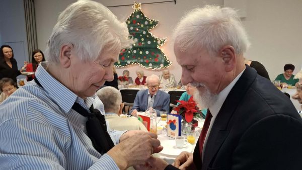 Seniorzy dzielący się opłatkiem