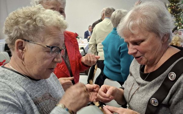 Seniorzy dzielący się opłatkiem