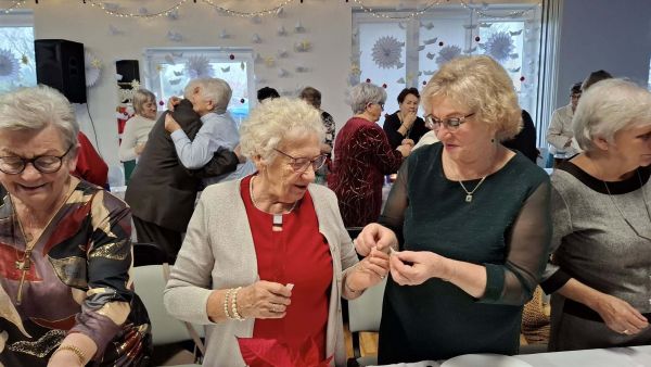 Seniorzy dzielący się opłatkiem