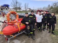 Strażacy OSP Złotoria przy łodzi motorowej