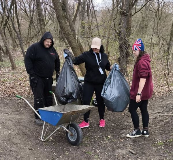 Ludzie sprzątąjący śmieci do taczki