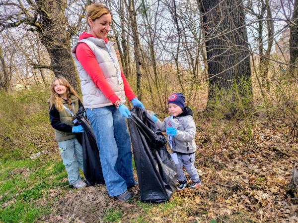 Mama z dwójka dzieci sprzątająca śmieci